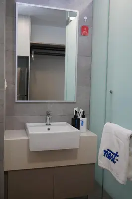 a bathroom with a white sink and a mirror at Riveria City KL Sentral by Nest Suite in Kuala Lumpur
