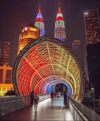 a bridge with colorful lights in a city at night at VibeHaus 11px 2R2B Pavillion Bukit Bintang 1mins in Kuala Lumpur