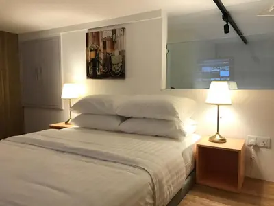 a bedroom with a bed with white sheets and two lamps at Bangsar LRT Suites EST by LSA in Kuala Lumpur