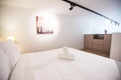 a white bed with a towel on top of it at Bangsar LRT Suites EST by LSA in Kuala Lumpur