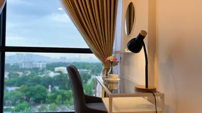 a desk with a lamp and a chair in front of a window at The Thant Suite in Kuala Lumpur