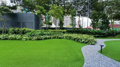 a garden with green grass and a walkway at The Thant Suite in Kuala Lumpur