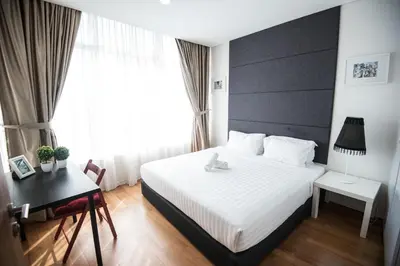 a bedroom with a white bed and a desk and a window at Vortex KLCC by LSA in Kuala Lumpur