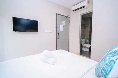 a white room with a bed with a tv on the wall at Swing & Pillows - TAR UMT Setapak in Kuala Lumpur