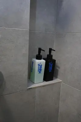 two bottles ofodorizers sitting on a shelf in a bathroom at Riveria City KL Sentral by Nest Suite in Kuala Lumpur