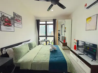 a bedroom with a bed and a flat screen tv at Neu Suites by Cozy Homes Near Gleneagles, KLCC & LRT in Kuala Lumpur