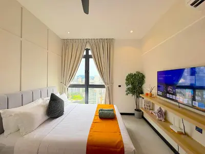 a bedroom with a large bed and a large tv at Neu Suites by Cozy Homes Near Gleneagles, KLCC & LRT in Kuala Lumpur