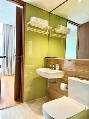 a bathroom with a toilet and a sink and a mirror at Sky Suites Klcc By Stayner in Kuala Lumpur