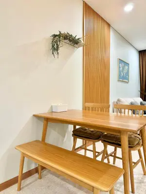 a dining room with a wooden table and benches at Sky Suites Klcc By Stayner in Kuala Lumpur