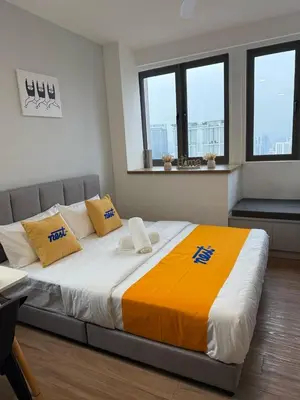 a large bed in a room with two windows at Nest Suites By KL in Kuala Lumpur