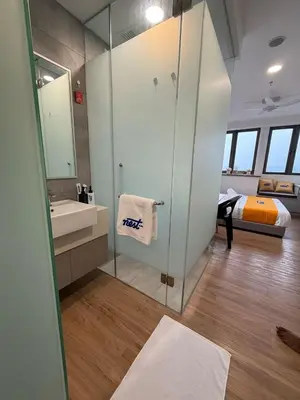 a bathroom with a shower and a sink and a bed at Nest Suites By KL in Kuala Lumpur
