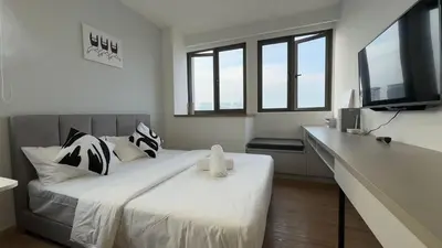 a bedroom with a large bed with a tv on it at Nest Suites By KL in Kuala Lumpur