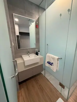 a bathroom with a sink and a glass shower at Nest Suites By KL in Kuala Lumpur