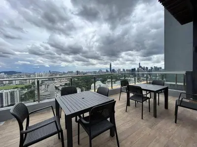 a balcony with tables and chairs and a view of a city at Suite16 Kuala Lumpur in Kuala Lumpur