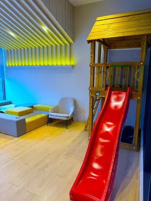 a red slide in a room with a bunk bed at In