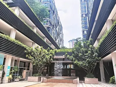 a building with trees in front of it with tall buildings at Arcoris Mont Kiara in Kuala Lumpur