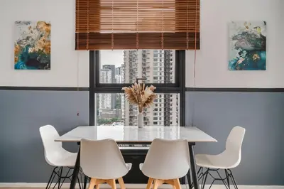 a dining room with a white table and white chairs at Arcoris Mont Kiara in Kuala Lumpur