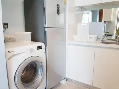 a kitchen with a washing machine and a refrigerator at Soho Suites Pavilion by LSA in Kuala Lumpur
