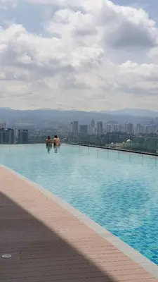 two people sitting in a swimming pool on top of a building at KL Mont Kiara The Ooak Entire Unit in Kuala Lumpur
