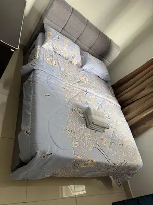 a bed with a blue comforter and pillows at Maxim City Lights in Kuala Lumpur