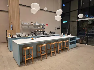 a large kitchen with a counter with stools at MidValley Bangsar Stylish Suite by DingDing in Kuala Lumpur