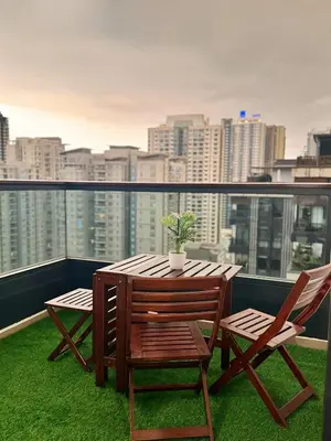 a table and chairs on a balcony with a city skyline at Arcoris Soho 163 Mall Luxury 2Bedroom With City View in Kuala Lumpur