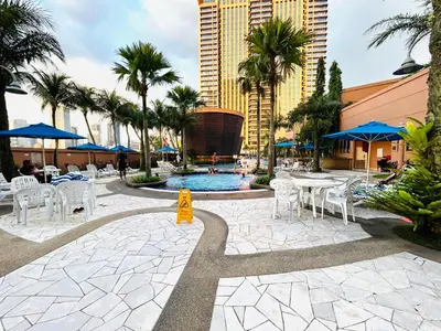 a resort with a pool and tables and chairs at DYNAMIC SUITES by TIMES SQUARE KL in Kuala Lumpur