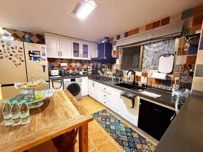 a kitchen with white cabinets and a wooden counter top at Bintang Home in Kuala Lumpur