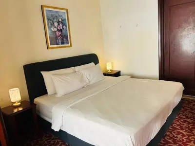 a bedroom with a large white bed with two night stands at TIMES SQUARE SERVICE SUITE at KUALALUMPUR in Kuala Lumpur
