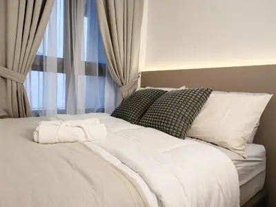 a bed with white sheets and pillows next to a window at TRX Agile Bukit Bintang 2 Bedroom Deluxe Suites in Kuala Lumpur