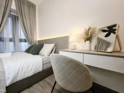 a bedroom with a white bed and a chair at TRX Agile Bukit Bintang 2 Bedroom Deluxe Suites in Kuala Lumpur