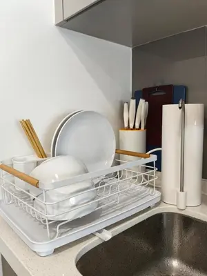 a kitchen counter with a dish drying rack next to a sink at TRX Agile Bukit Bintang 2 Bedroom Deluxe Suites in Kuala Lumpur