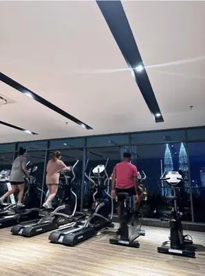 a group of people exercising on exercise bikes in a gym at Dreamy Destiny Suites At KLCC Swimming Pool View in Kuala Lumpur