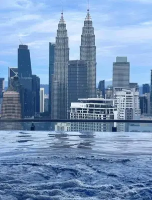 a view of a city skyline from the water at Dreamy Destiny Suites At KLCC Swimming Pool View in Kuala Lumpur