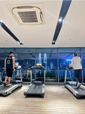 a group of people on treadmills in a gym at Dreamy Destiny Suites At KLCC Swimming Pool View in Kuala Lumpur