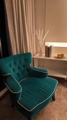 a green chair in a living room with a table at Expressionz KLCC By Laze Home in Kuala Lumpur