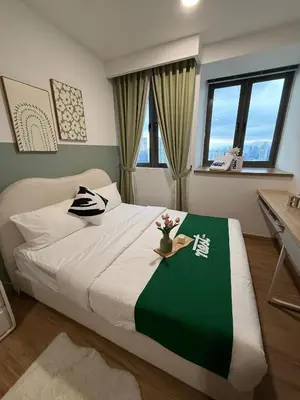 a bedroom with a large bed with a green and white blanket at Riveria City Kuala Lumpur By Nest Suites in Kuala Lumpur