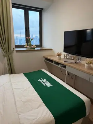 a hotel room with a bed and a desk with a television at Riveria City Kuala Lumpur By Nest Suites in Kuala Lumpur
