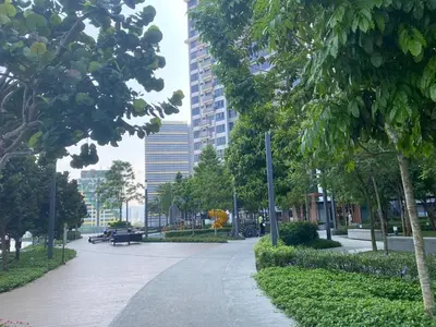 a walkway in a park with trees and buildings at Sydney Sunset 3BR M Vertica Near MRT by RumaBnB in Kuala Lumpur