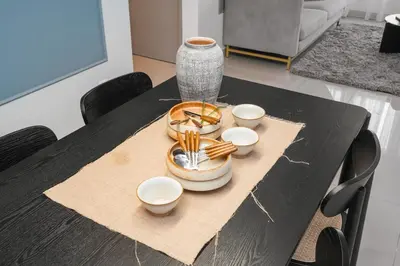 a black table with plates and bowls and a vase at Sydney Sunset 3BR M Vertica Near MRT by RumaBnB in Kuala Lumpur
