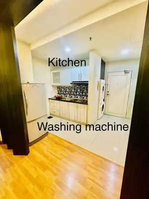 a kitchen with a refrigerator and a washing machine at Parkview Family Suite klcc with views in Kuala Lumpur