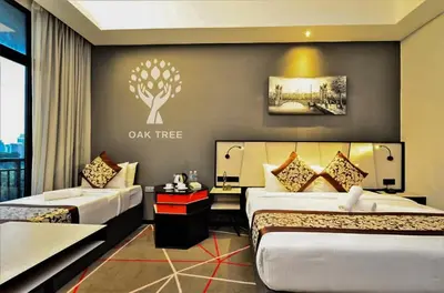 a hotel room with two beds and a tree sign on the wall at The Oak Room At M101 in Kuala Lumpur