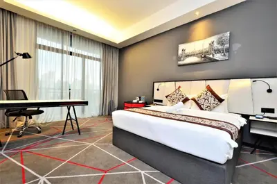a hotel room with a large bed and a desk at The Oak Room At M101 in Kuala Lumpur
