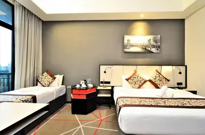 a hotel room with two beds and a window at The Oak Room At M101 in Kuala Lumpur