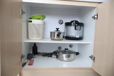 a cupboard with pots and pans sitting on it at Cozy kenwingston platz kl 2-5pax 2BR&2BR Klcc view free paikin wifi1907 in Kuala Lumpur