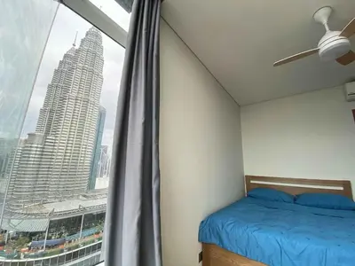 a bedroom with a bed and a large window at Sky Suites Luxury unit with KLCC view in Kuala Lumpur