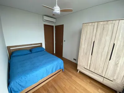 a bedroom with a blue bed and a wooden cabinet at Sky Suites Luxury unit with KLCC view in Kuala Lumpur