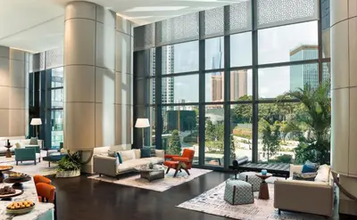 a living room with large windows and furniture at Kimpton Naluria Kuala Lumpur by IHG in Kuala Lumpur