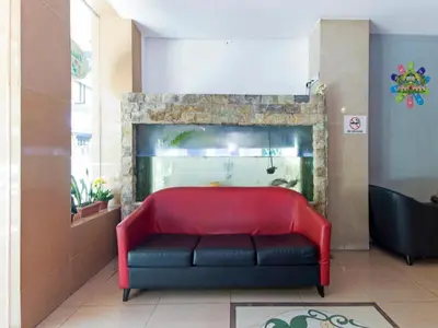 a red couch sitting in front of a fireplace at OYO 175 Lotus Hotel in Kuala Lumpur