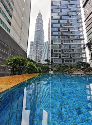 a large swimming pool in a city with tall buildings at Acappella Kuala Lumpur City Centre in Kuala Lumpur